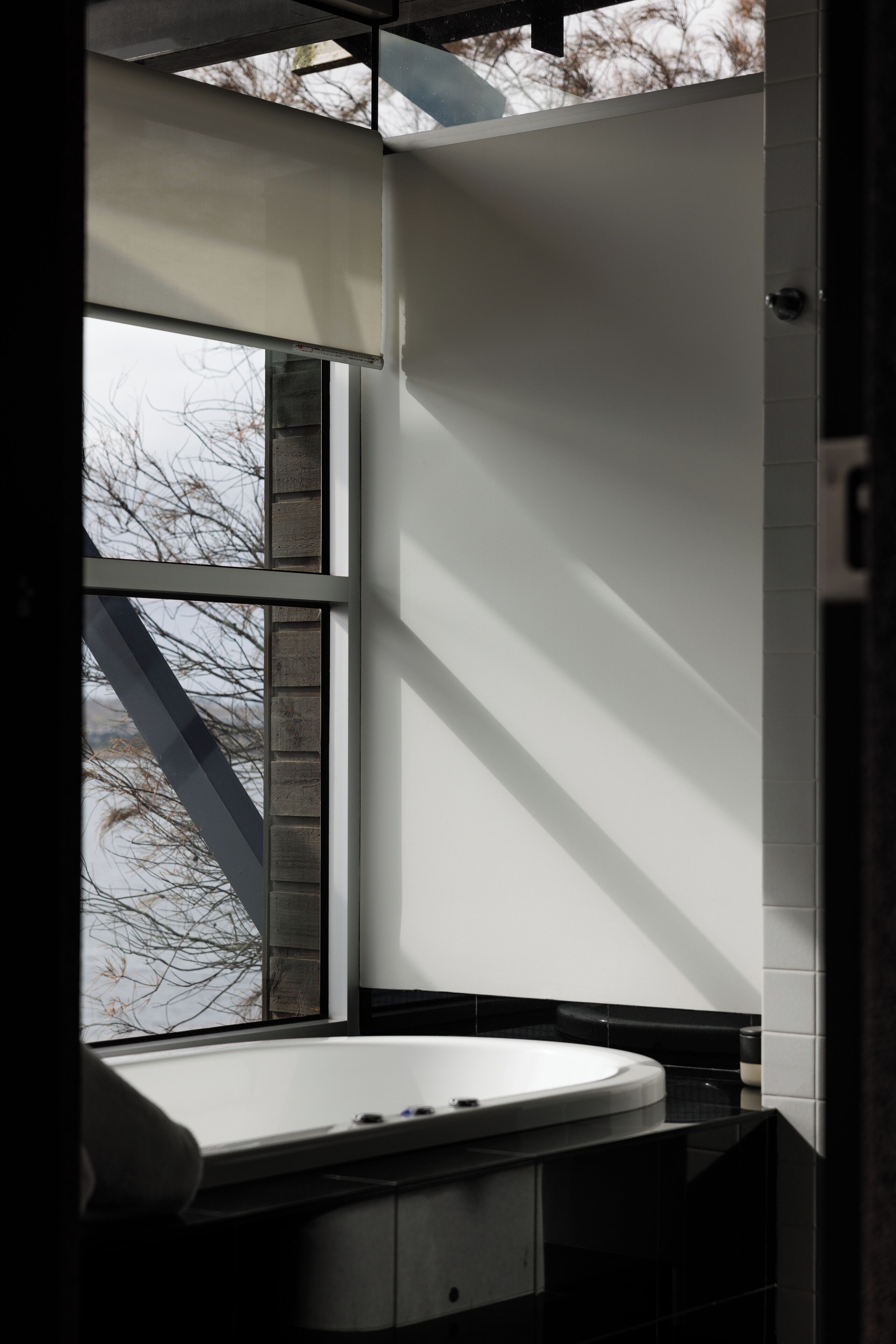 Een badkamer met raam, bad en wastafel.
