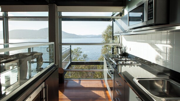 Una cucina moderna con vista su un lago e montagne.
