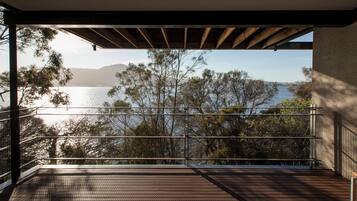 A balcony with a view of a lake and trees.