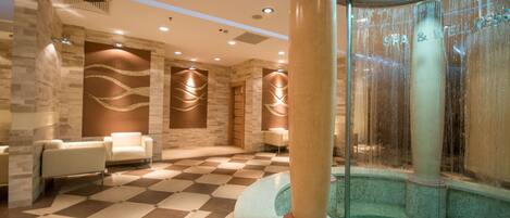 A spa area with a checkered floor, a hot tub, and a column.