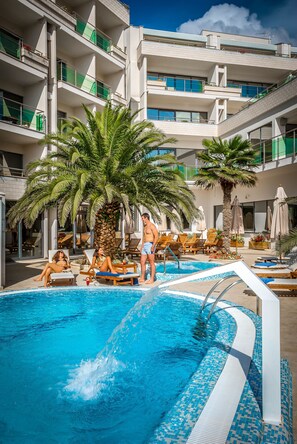 Piscine couverte, piscine extérieure, parasols de plage, chaises longues