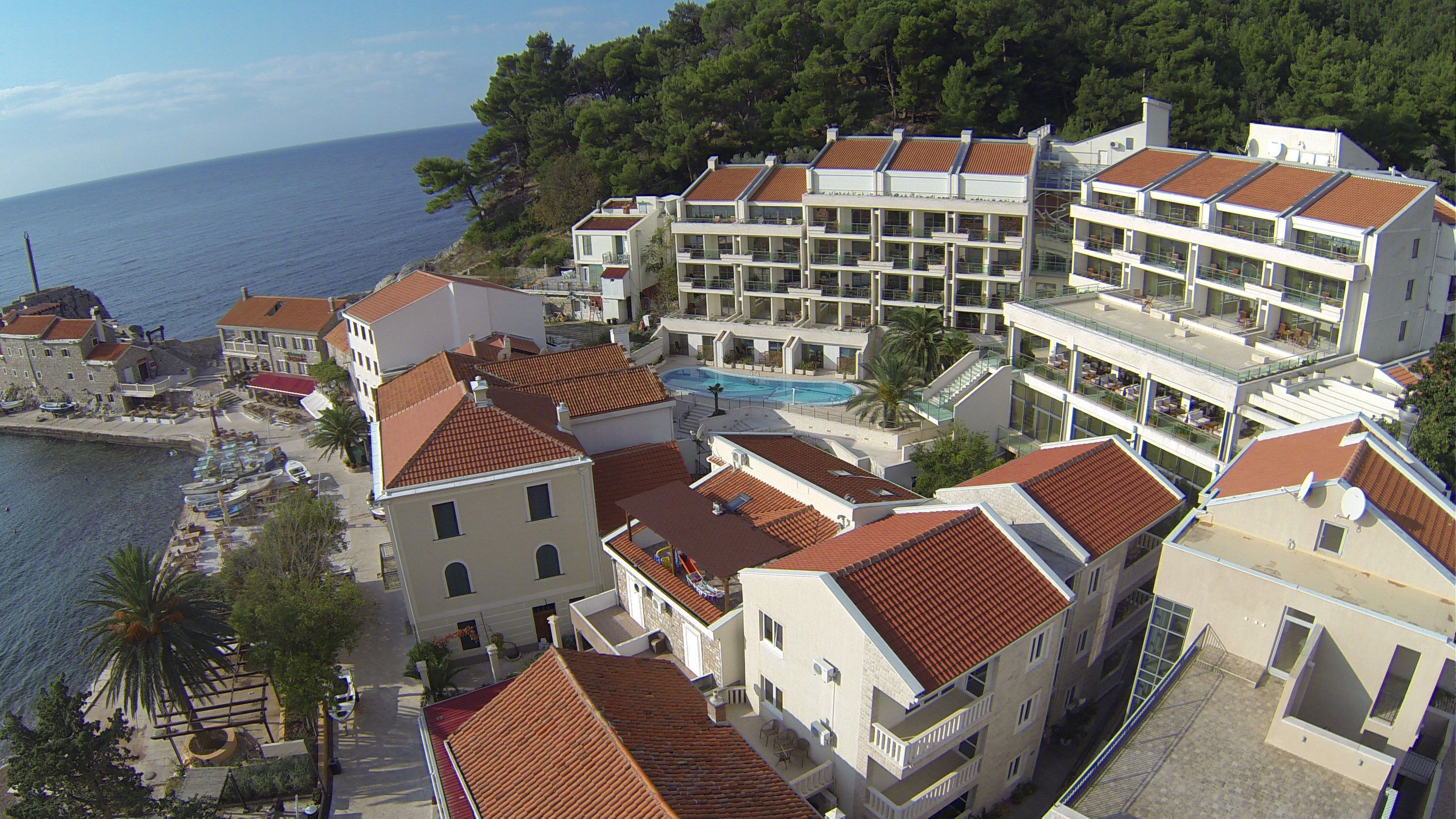 Um hotel à beira-mar com várias varandas, piscina e vista para o mar.