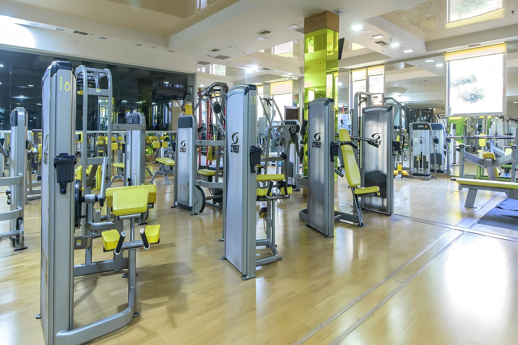 Un gimnasio con diversas máquinas de ejercicio y bancos.
