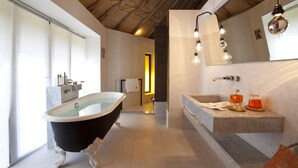 A modern bathroom with a freestanding bathtub, a marble sink, and a large mirror. - Les 5 Djellabas (Marrakech)