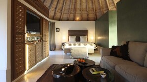 A hotel room with a large bed, a sofa, a TV, and a minibar. - Les 5 Djellabas (Marrakech)