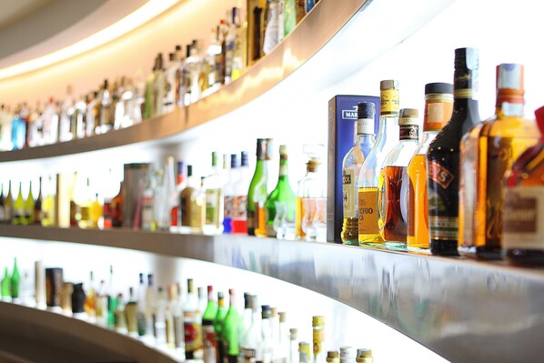 A bar with shelves stocked with various liquor bottles.