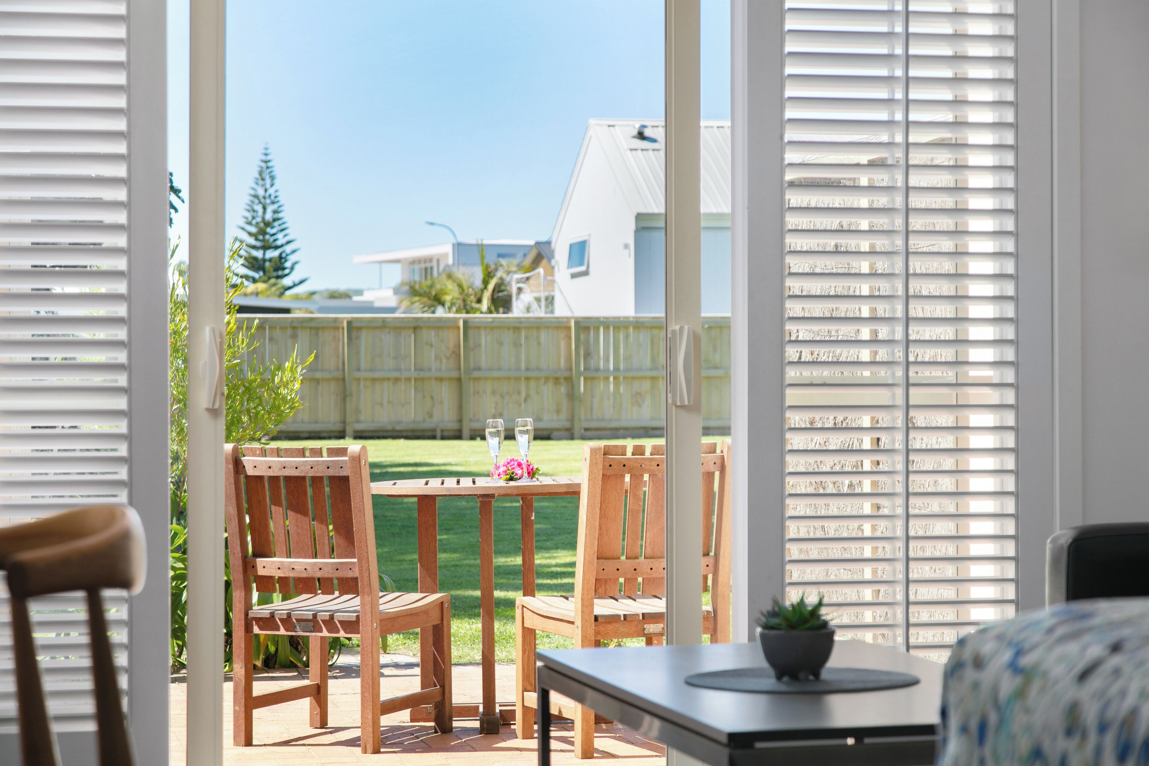 Eine Terrasse mit Holzmöbeln, einem Tisch und einem Blumentopf.