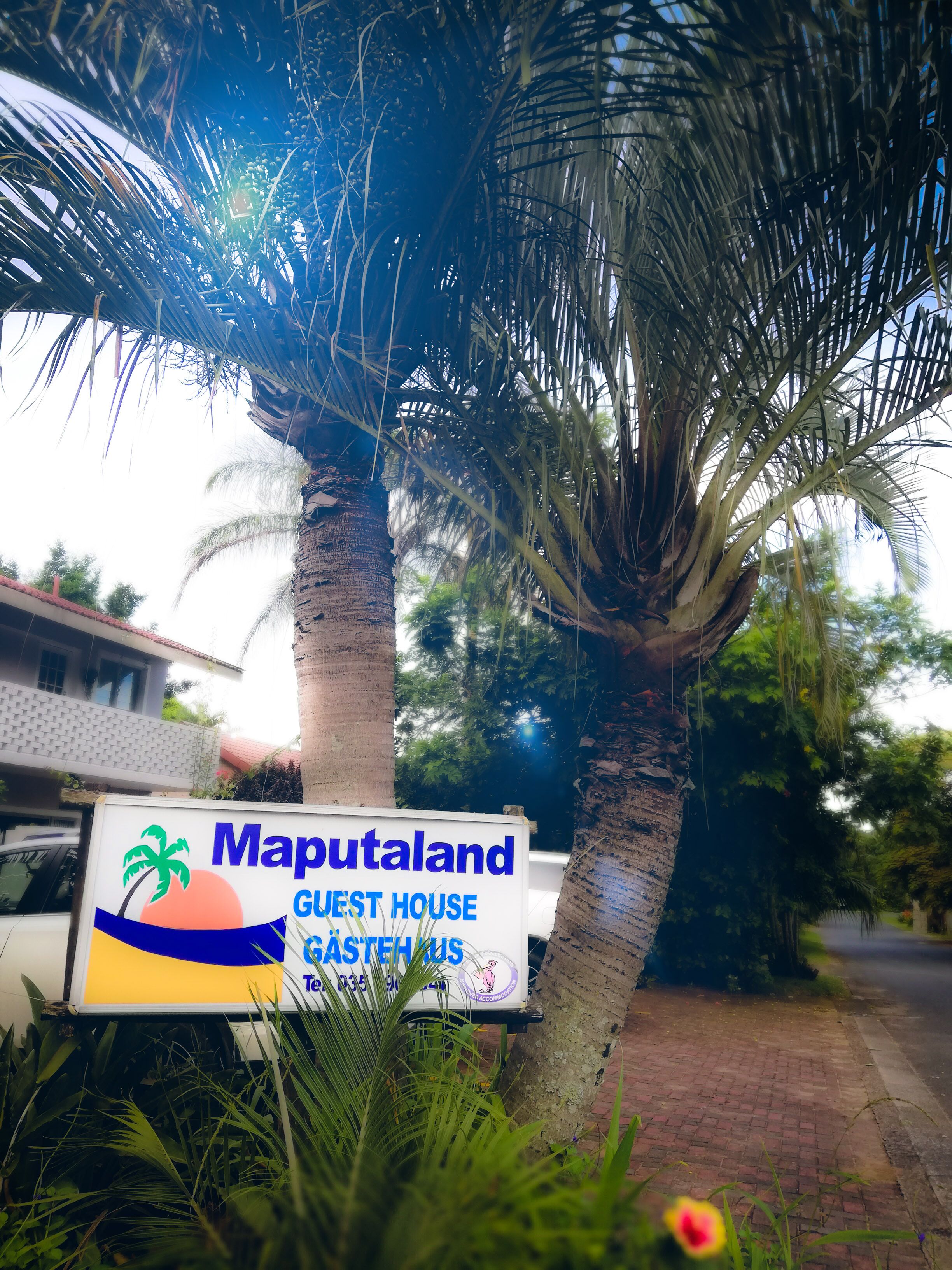 A sign for Maputaland Guest House with contact details.