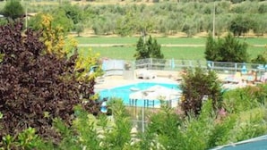 Vista de una zona de piscina con una clara visualización de un castillo al fondo.