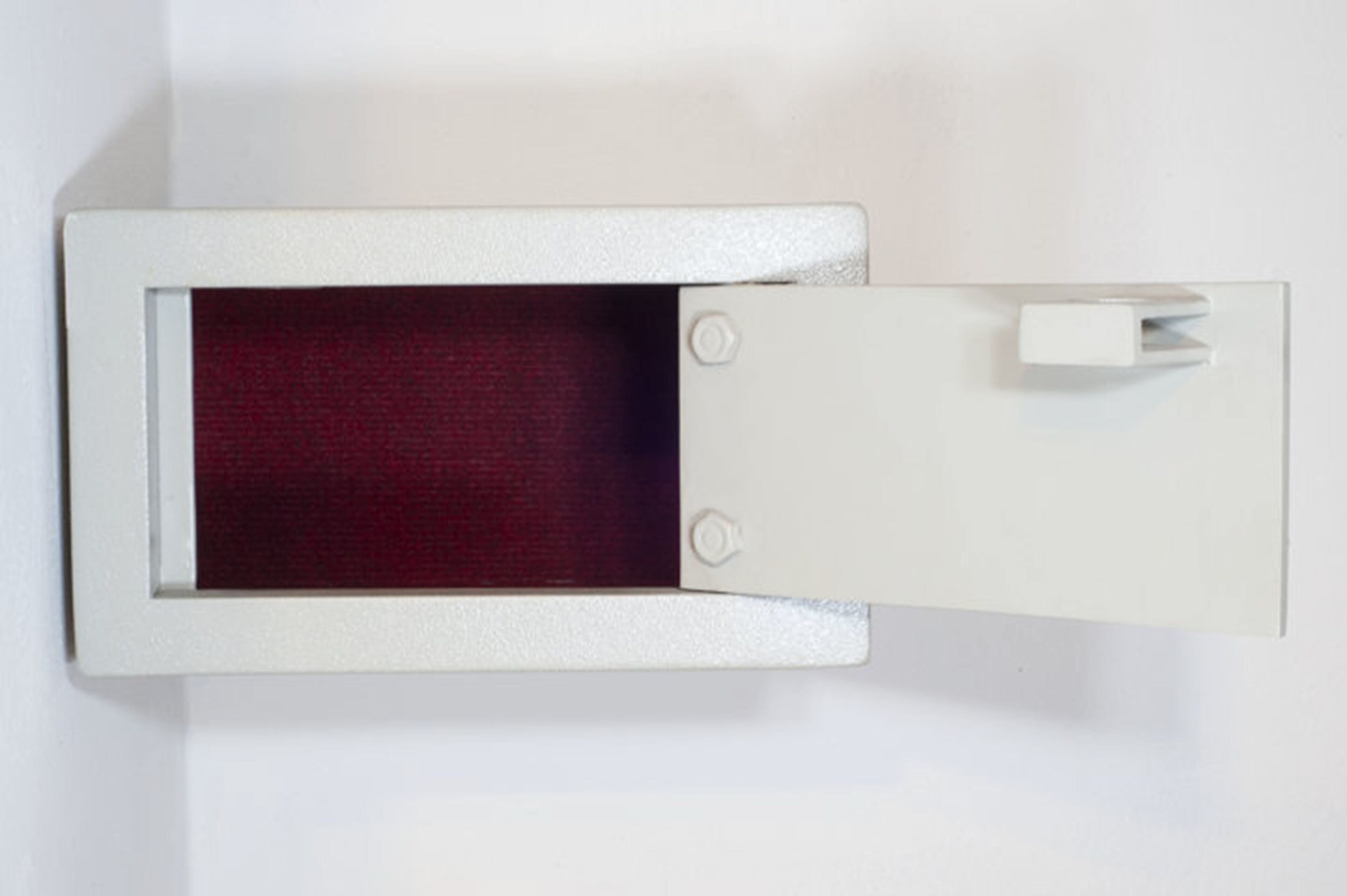 Un objeto blanco y rectangular con superficie texturizada e interior rojo, posiblemente un mueble o equipo.