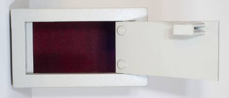 Un objeto blanco y rectangular con superficie texturizada e interior rojo, posiblemente un mueble o equipo.