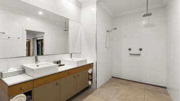 Een moderne badkamer met twee wastafels, een grote spiegel en een douchegedeelte.