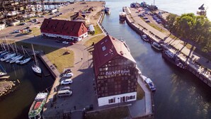 An aerial view of the Old Mill Hotel with a dock area, boats, and a marina. - Old Mill Hotel (Klaipeda)