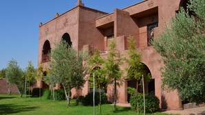 Un bâtiment à la façade brun rougeâtre, doté de nombreuses arcades et de balcons.