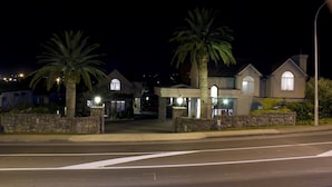 A residential area with houses featuring stone walls and palm trees. - Lodge Bordeaux (Whangarei)