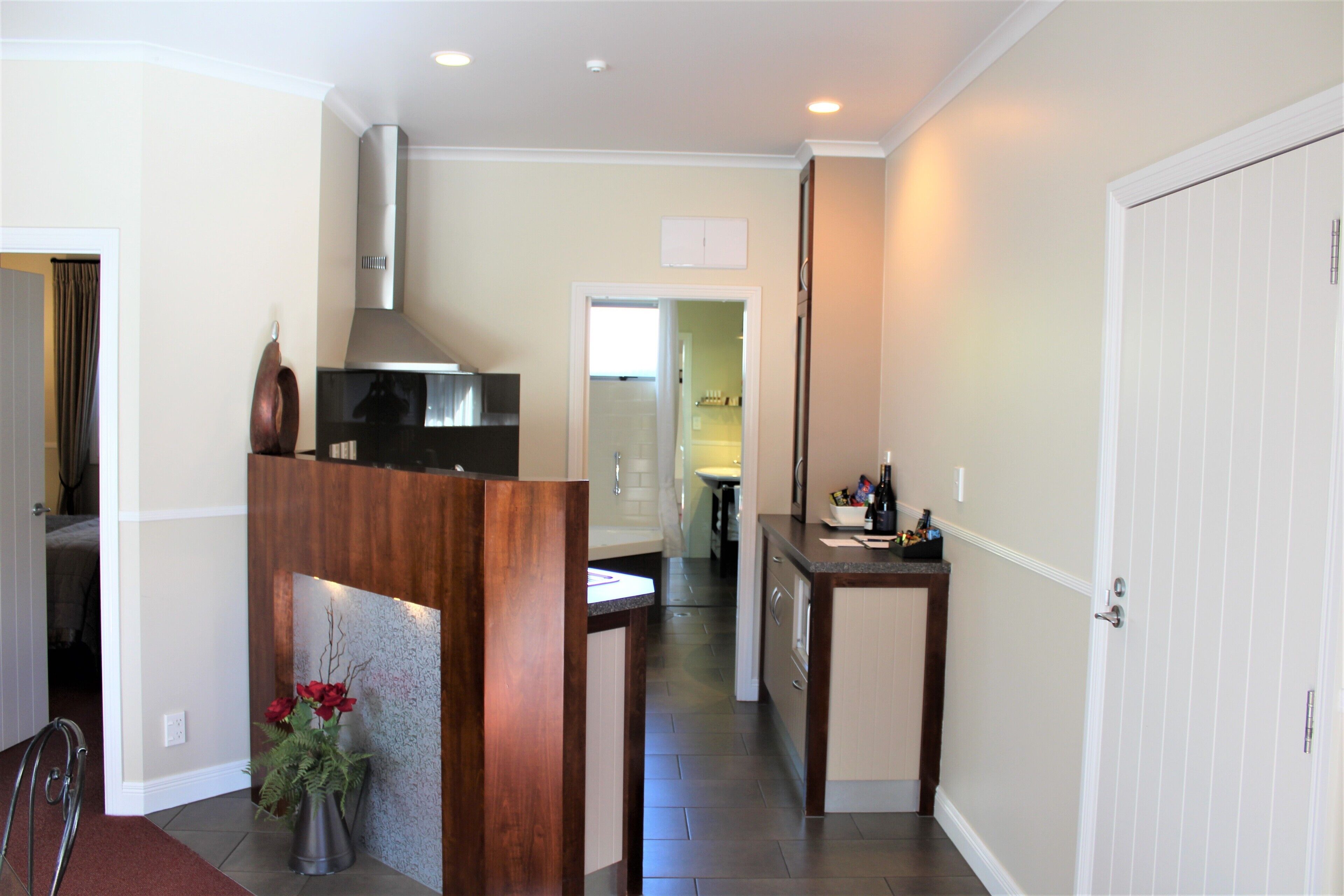 A modern kitchen with a central island, a built-in stove, and a stainless steel range hood.