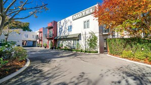 Ein Motel mit moderner Fassade, blauem Himmel und Herbstlaub.