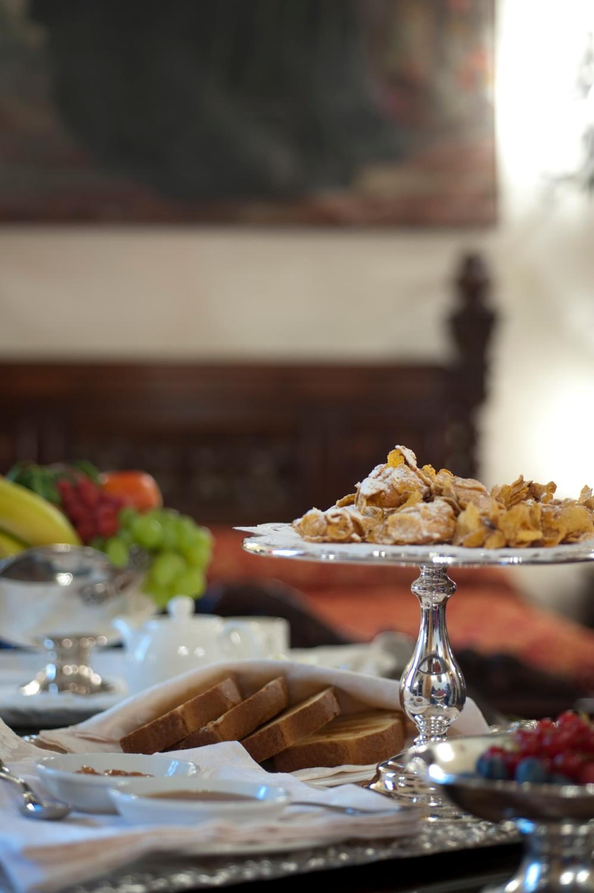 Un bufé de desayuno con diferentes alimentos y un cuadro al fondo.
