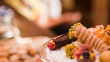 En buffetbod med forskellige desserter og en person i baggrunden.