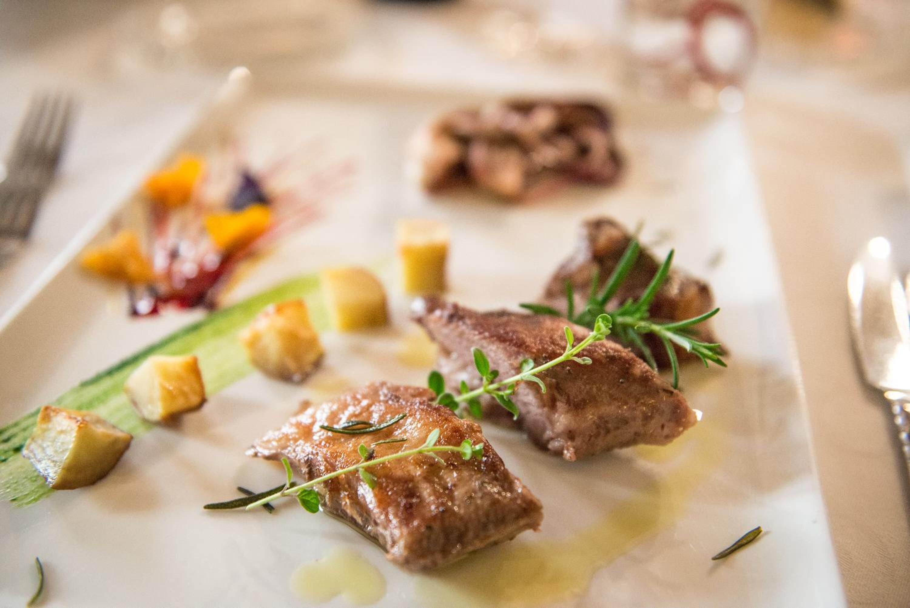 Un plato con carne, verduras y salsa.