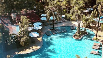 Una piscina al aire libre, sombrillas, sillones reclinables de piscina