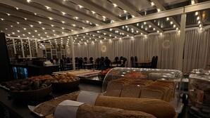 Ein Buffet mit verschiedenen Speisen, darunter Brot, Gebäck und Sandwiches.