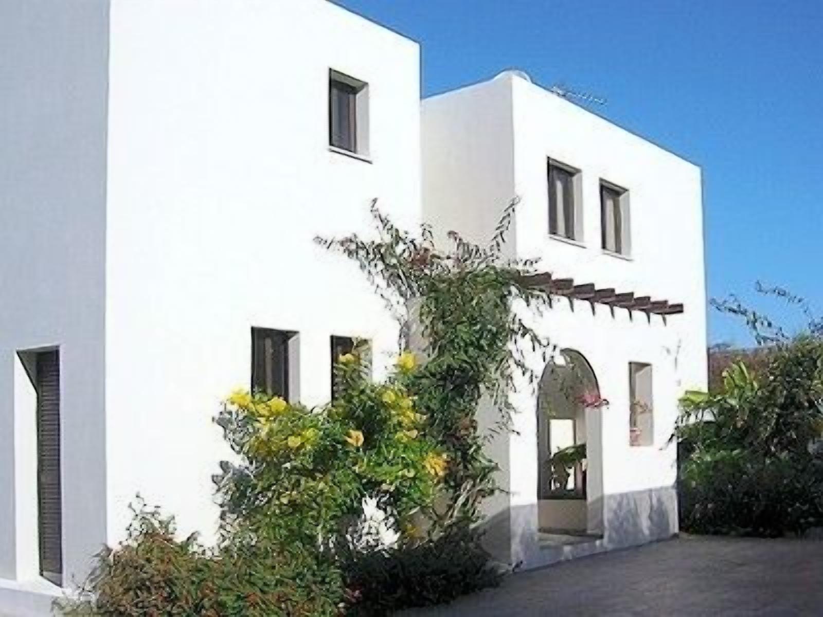 A white building with multiple windows and a small entrance.