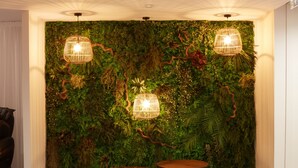 A room with a green wall covered in plants and two wooden tables. - Kastel Wellness Hôtel Thalasso & Spa (Benodet)