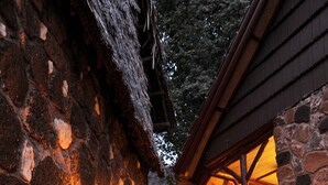 Ein Steinweg führt zu einem Gebäude mit einem strohgedeckten Dach und Steinmauern.