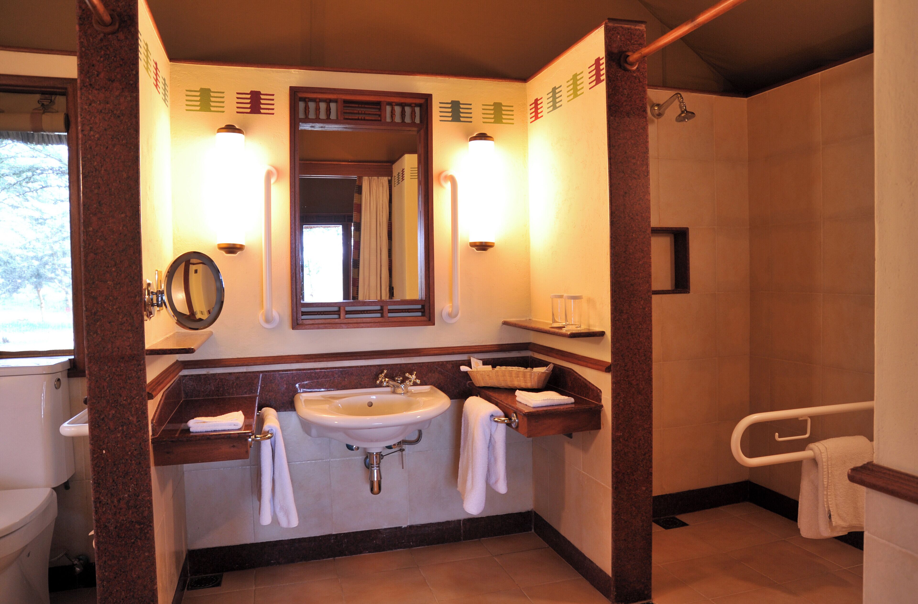 A bathroom with a sink, mirror, towel rack, and shower area.