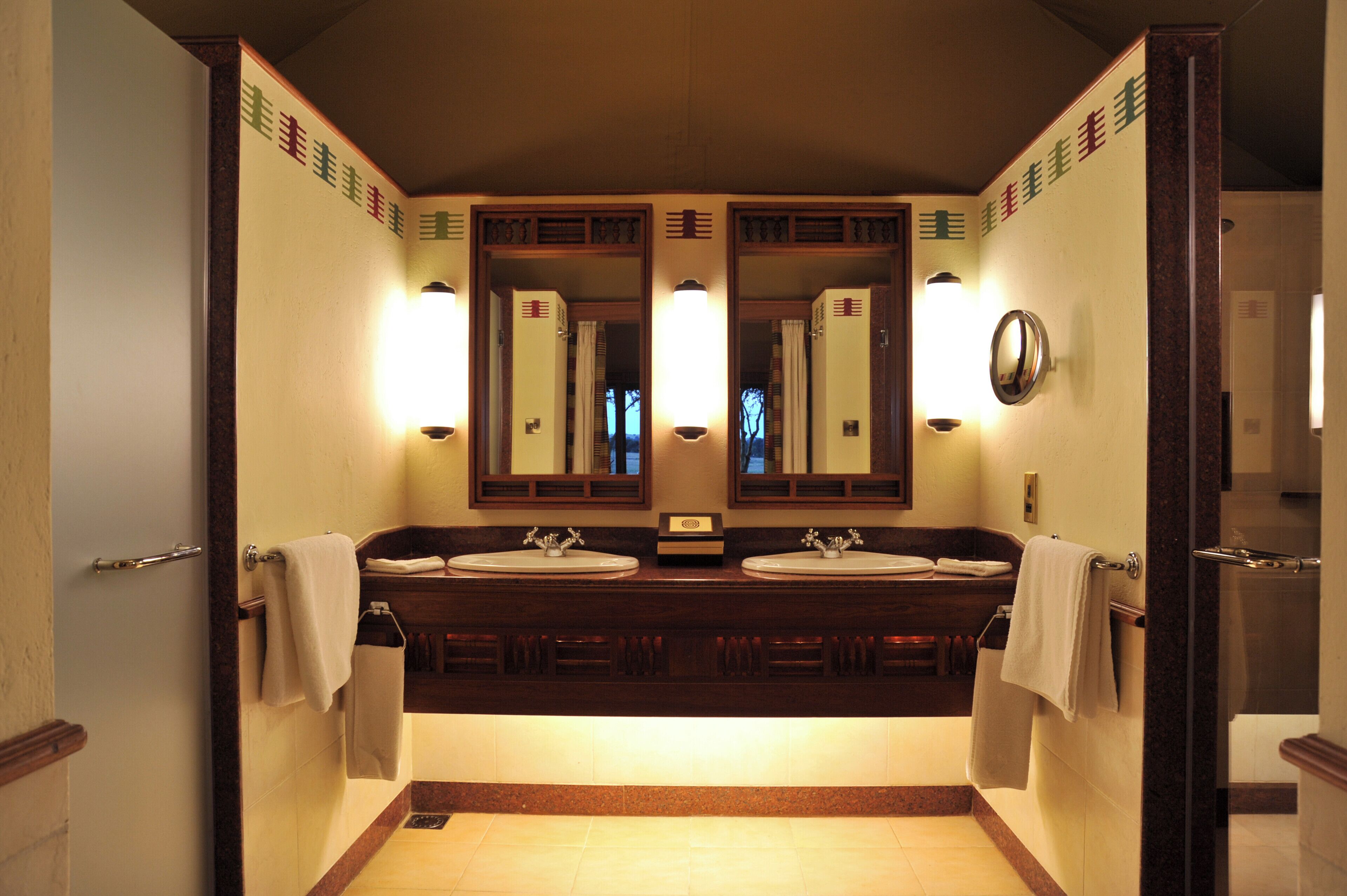 A bathroom with two sinks, a mirror, and a towel rack.