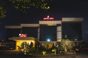 A modern hotel with a prominent sign reading 'HOTEL ASIA' and a smaller sign for 'Asia Vaishno Devi'. - Hotel Asia Vaishno Devi (Reasi)