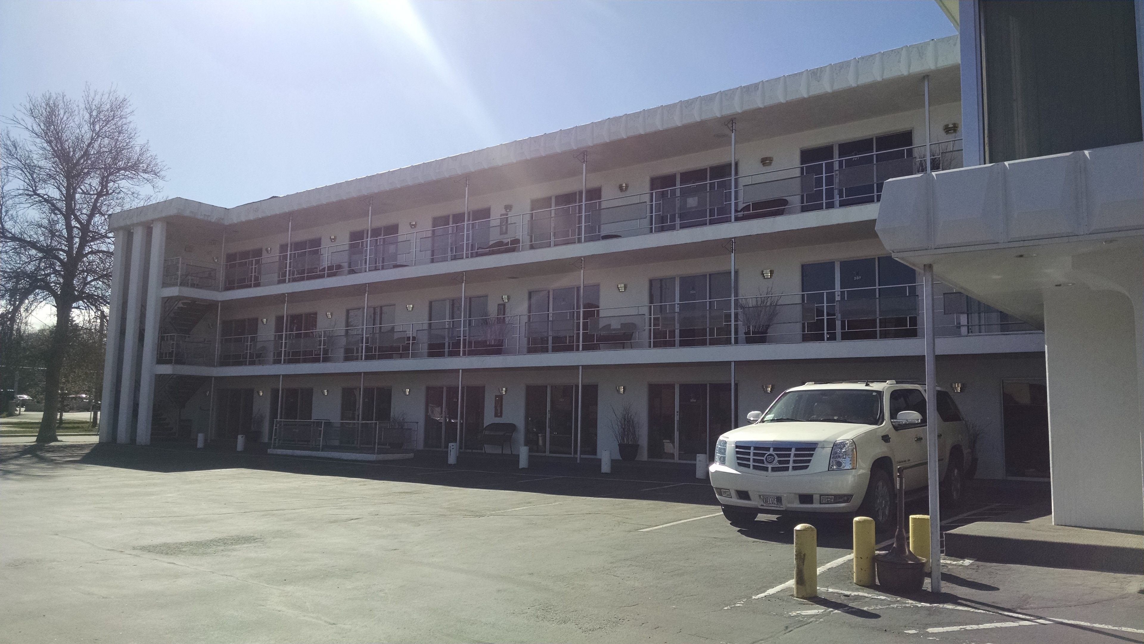 A multi-story building with a parking area in front.