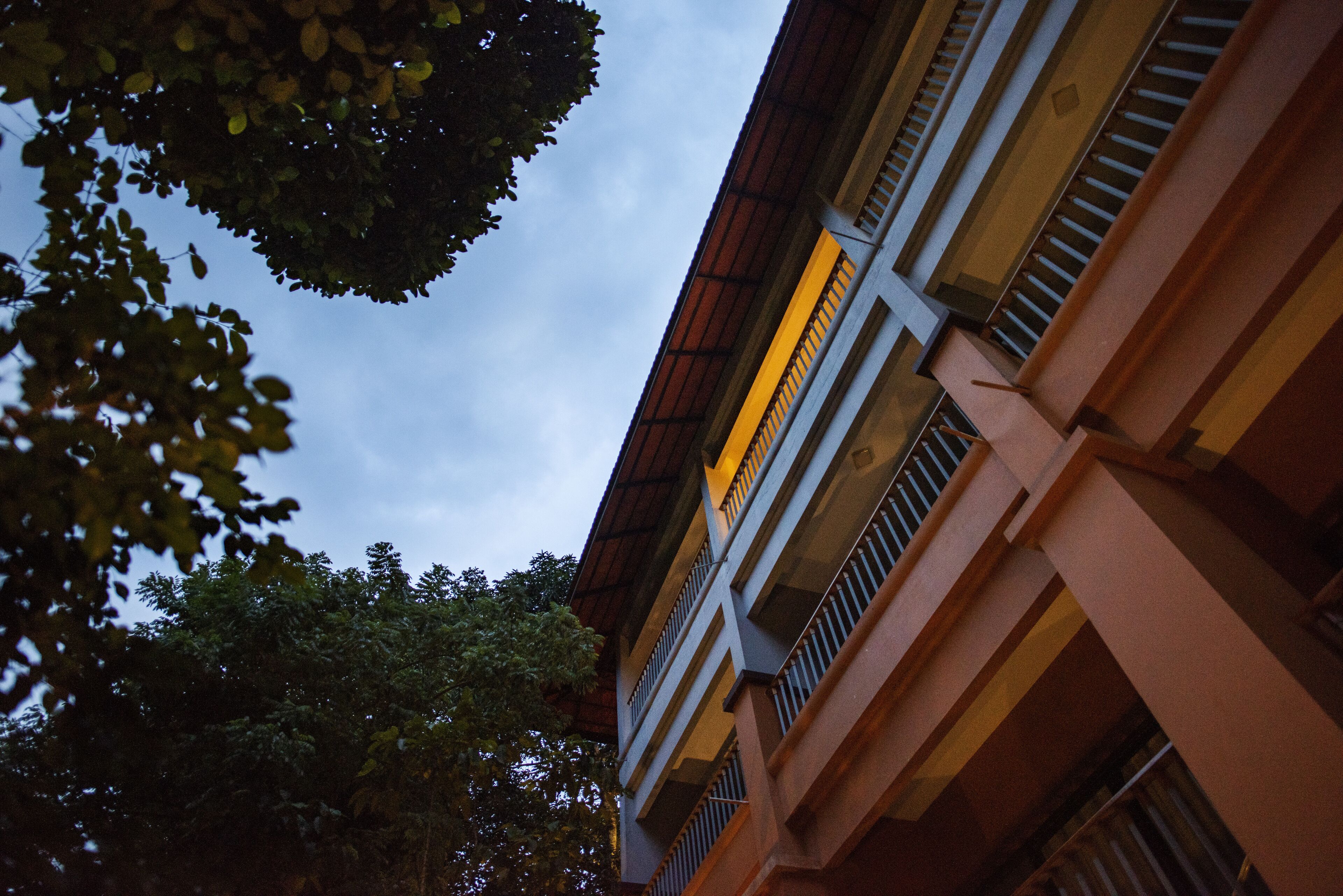 Um edifício com várias andares, varandas e vista para o céu.