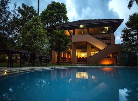 Una piscina al aire libre, sillones reclinables de piscina