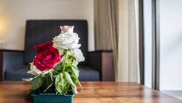 Ein Holztisch mit einer türkisfarbenen Vase, gefüllt mit roten und weißen Rosen.
