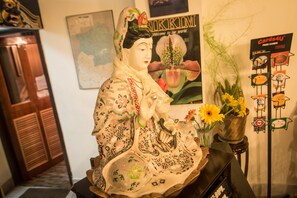A decorative statue with intricate patterns, a vase with sunflowers, and a sign for Cards4U. - Central Hill Resort Gangtok (Gangtok)