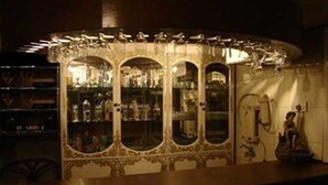 Una zona de bar con armarios de vidrio decorados y una estatua.