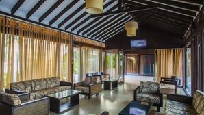Eine geräumige Lobby mit gestreiften Sofas, einem Couchtisch und einem an der Wand befestigten Fernseher.