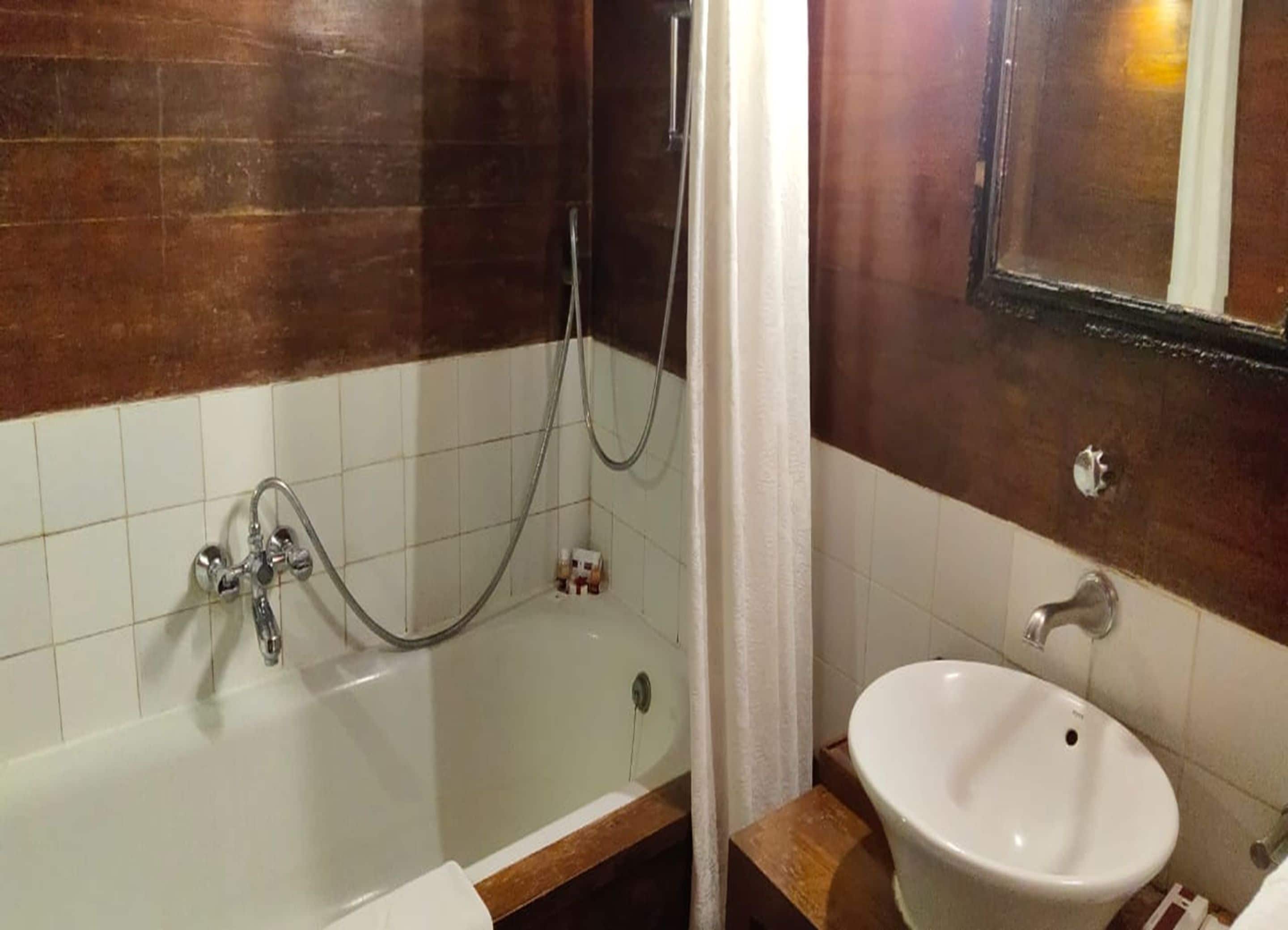 A bathroom with a bathtub, a shower, and a sink.