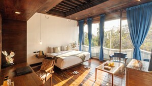 A bedroom with a bed, a wooden desk, a chair, and a view of the outdoors. - Le Dupleix (Puducherry)
