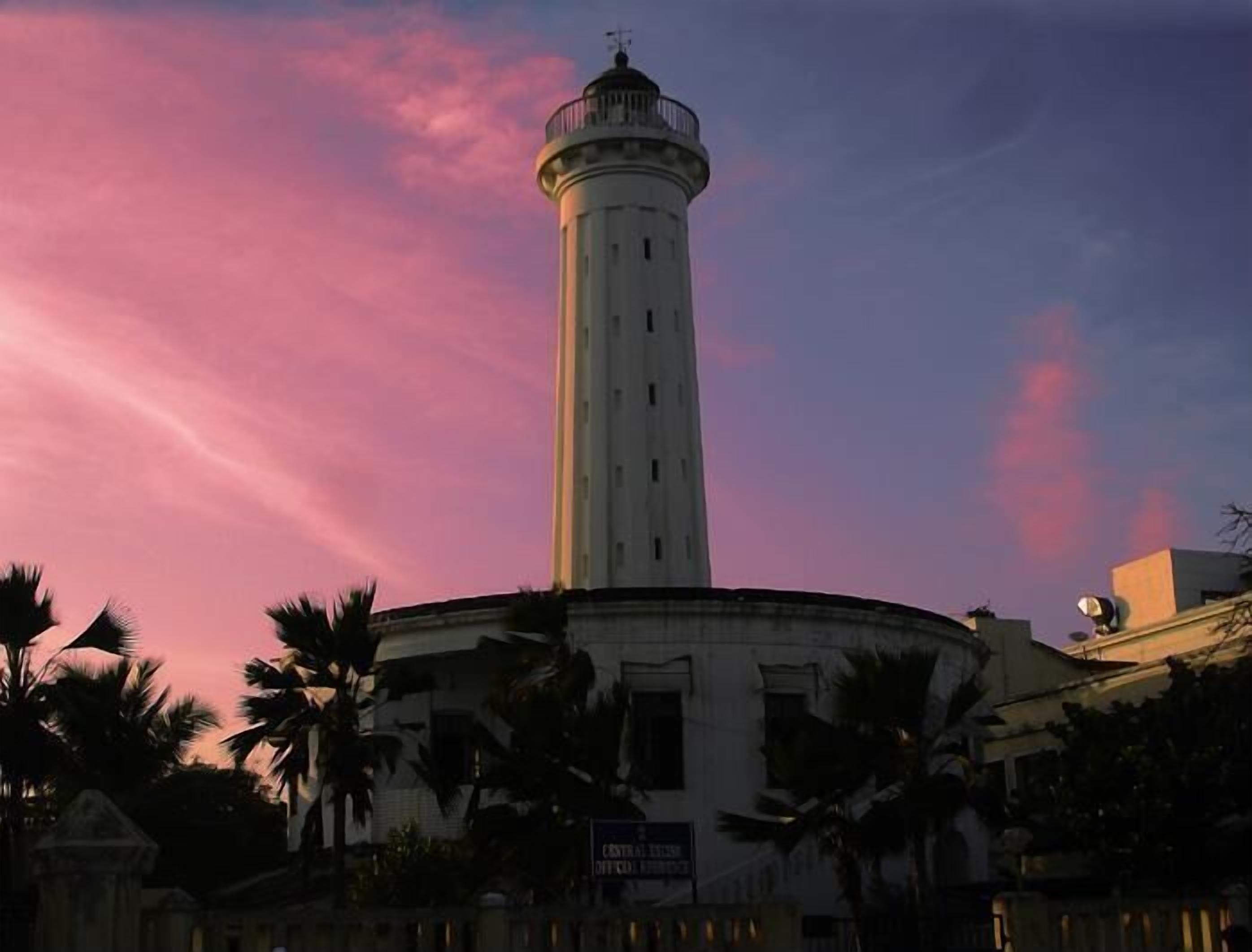 A lighthouse with a circular base and a tall, narrow tower.