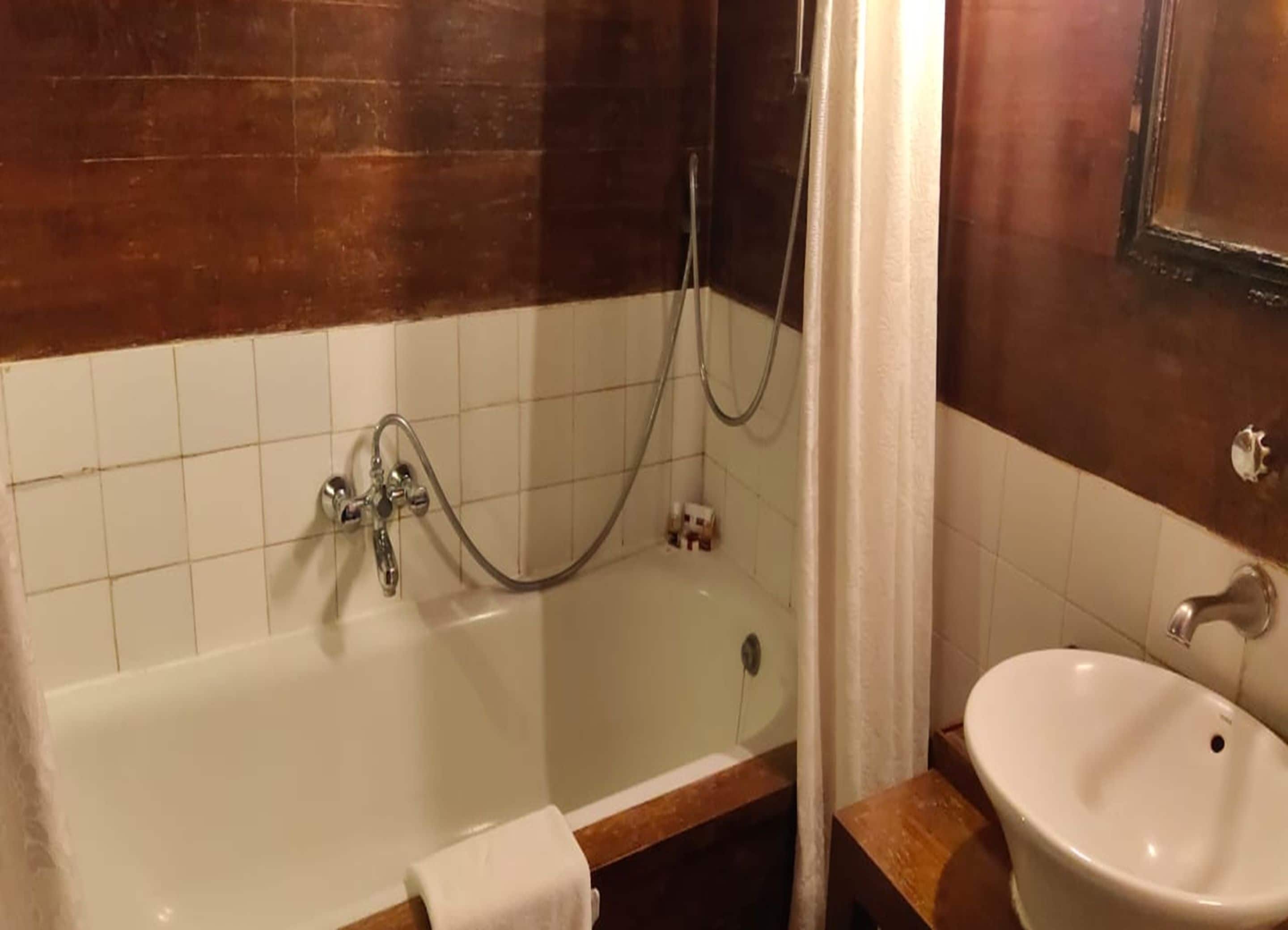 A bathroom with a bathtub, a shower, and a sink.