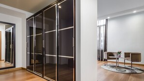 A modern room with a sliding glass door closet, a round table with two chairs, and a large mirror. - Eurostars Roma Aeterna (Rome)