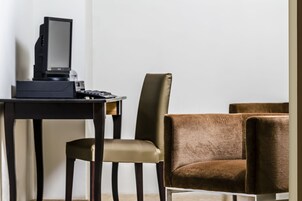 Una habitación moderna con un escritorio, una computadora y dos sillas.
