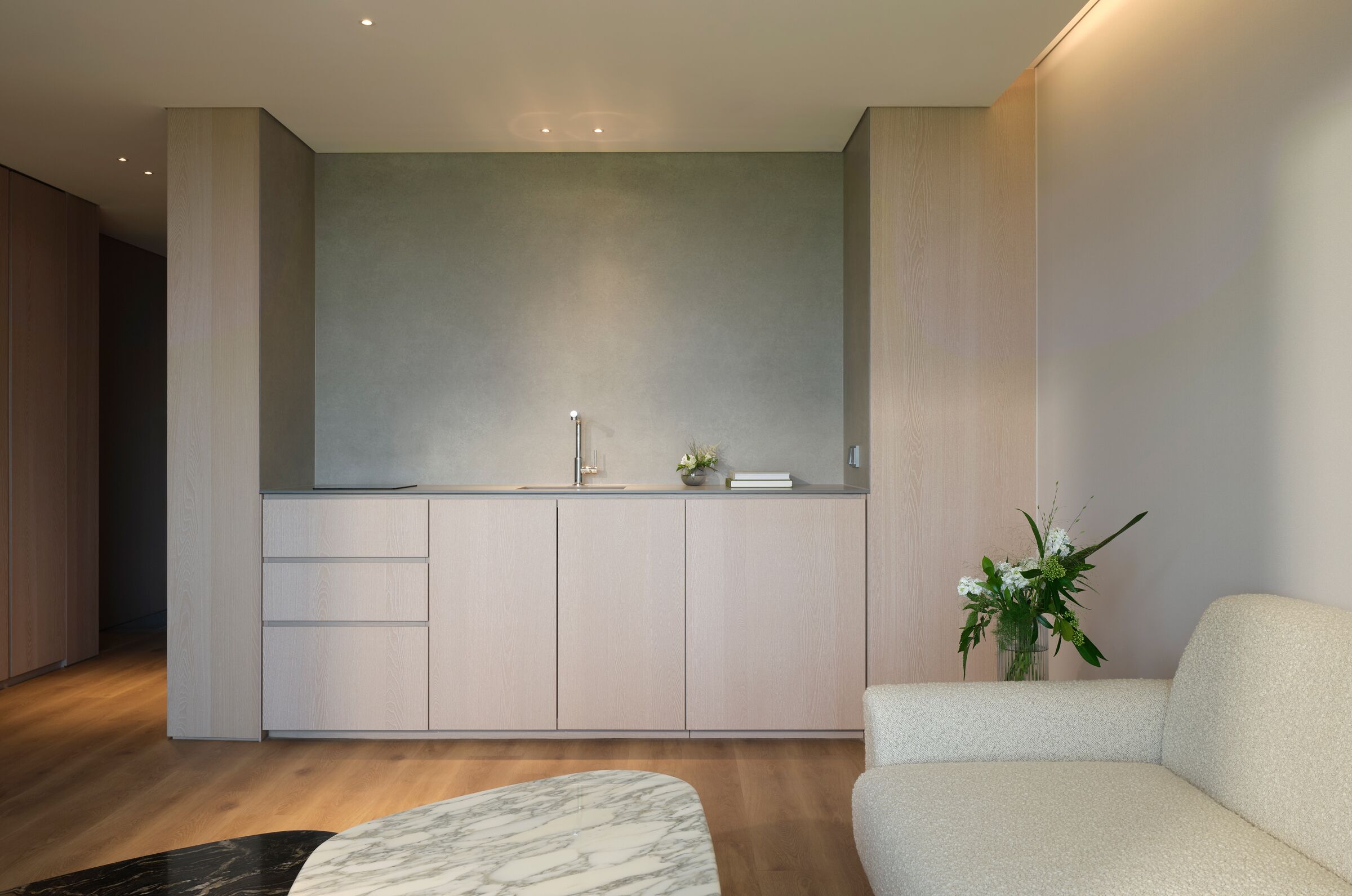 Een moderne keuken met een inbouw eiland, houten kastjes en een minimalistisch ontwerp.
