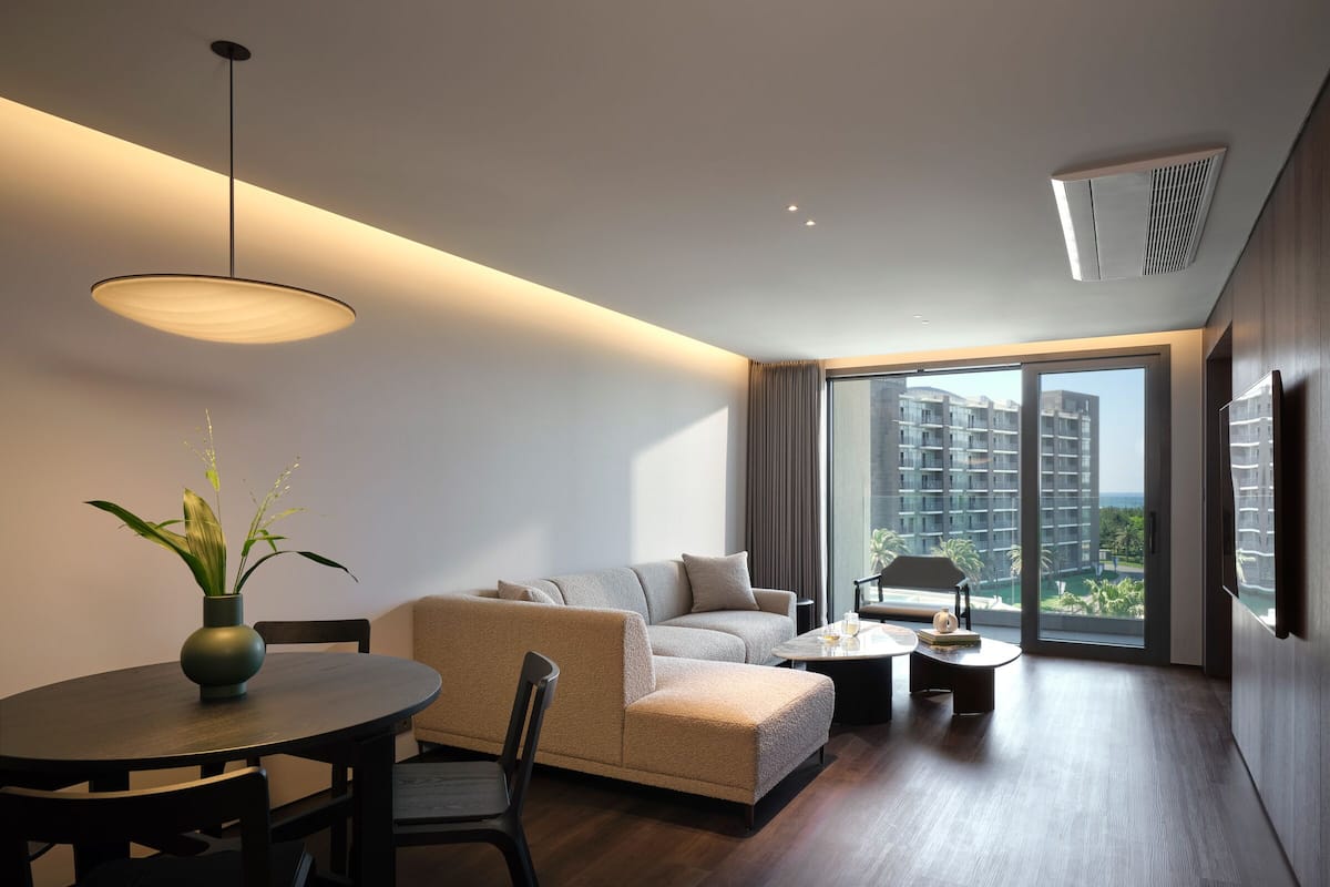 Un salon moderne avec un canapé, une table à manger et une vue sur des immeubles de grande hauteur.