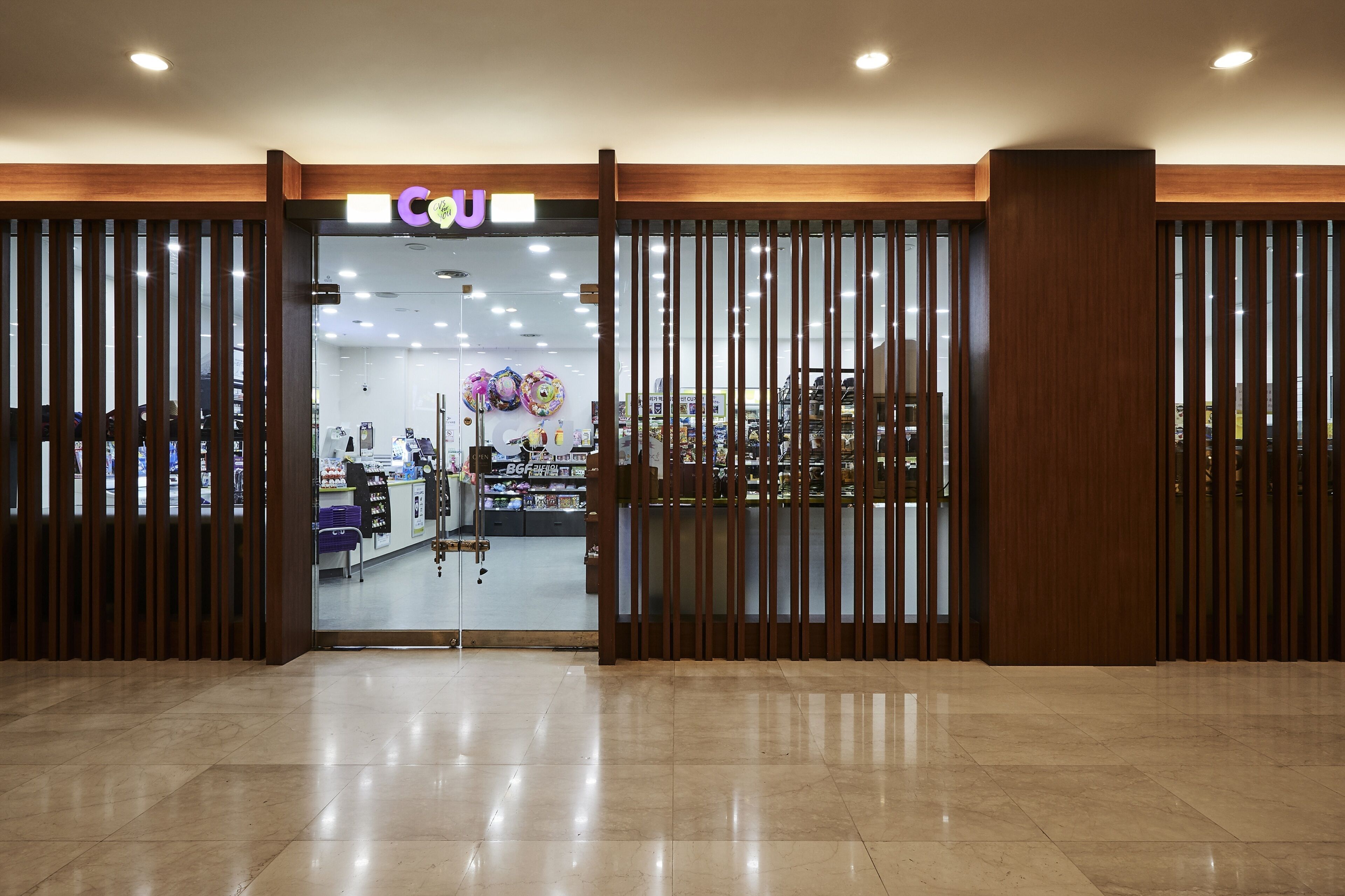 A store entrance with a wooden partition and a sign that reads 'COU'.
