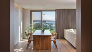 Una sala moderna con un gran ventanal, una mesa de comedor de madera y un sofá.