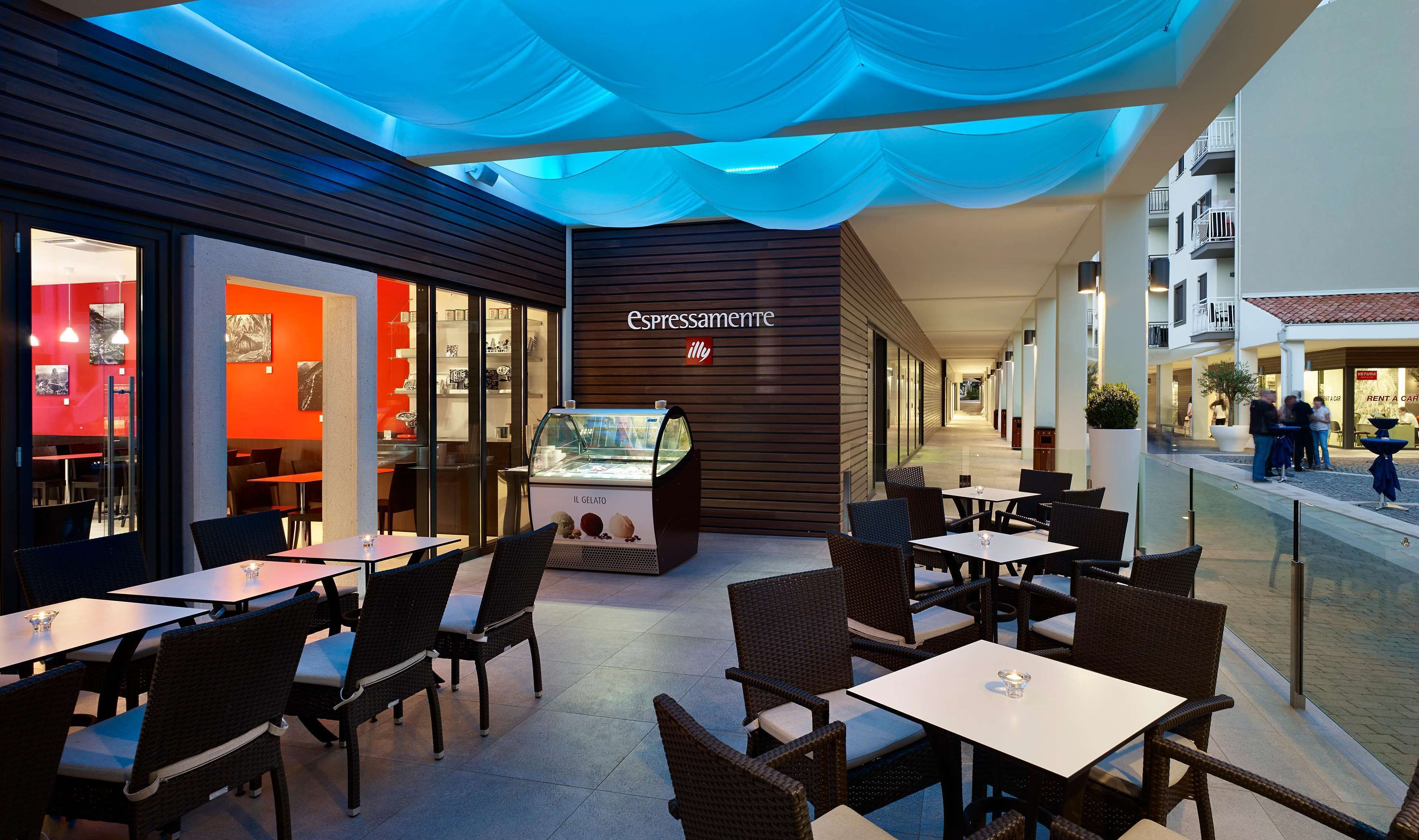 A café with outdoor seating, a gelato display, and a modern interior design.